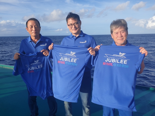 남태평양에서 조업중인 김민호 동원산업 주빌리호 선장(가운데)과 선원들이 '플라스틱 저감화 3개년 계획'의 슬로건 “No! Plastic! Yes! Blue Ocean!”이 적힌 티셔츠를 들고있다. 사진 동원산업 제공 [뉴스락]