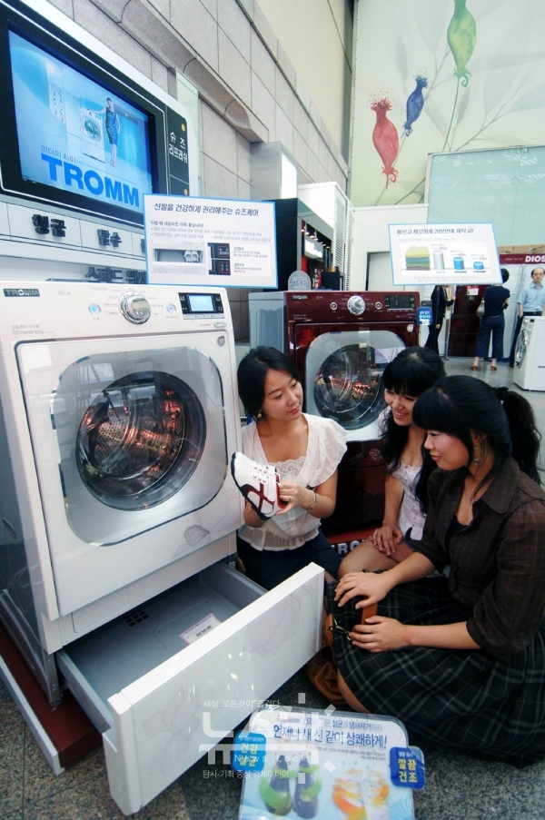 LG전자가 2008년 출시한 드럼세탁기에 탑재된 서랍형 신발관리기를 고객들이 체험하는 모습. 사진 LG전자 제공 [뉴스락]