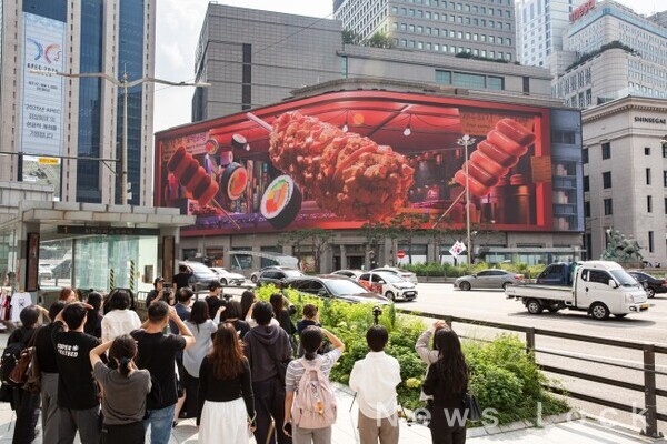 오는 11월 30일까지 명동 신세계 백화점 미디어월(신세계스퀘어)에서 공개되는 아트코리아랩  전시에서 시민과 관람객이 안종훈, 오지연 작가의 3D 아나모픽 미디어아트 작품 ‘다다명동(DaDa Myeongdong)’을 관람하고 있다.